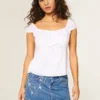 Mini-jupe-short en denim délavé moyen avec broderie en chaîne Mini-jupe-short en denim délavé moyen avec broderie en chaîne