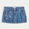 Mini-jupe-short en denim délavé moyen avec broderie en chaîne Mini-jupe-short en denim délavé moyen avec broderie en chaîne