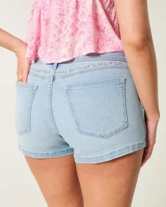 Short en denim taille basse, coupe ajustée, délavage clair, broderies florales